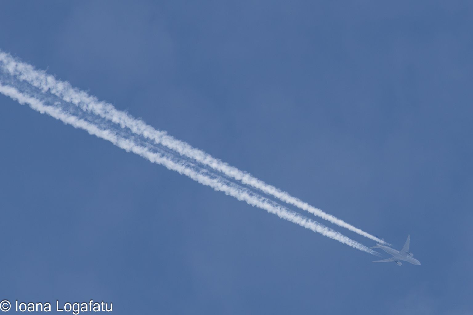 Contrails painting the blue sky in midday hours